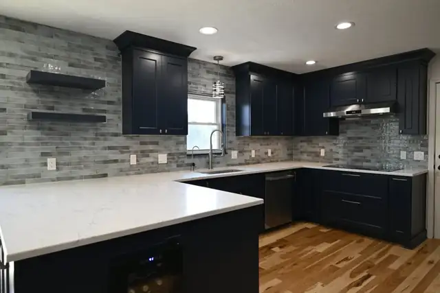 Navy kitchen remodel with open floating shelves, stone countertops and a new run of base cabinets
