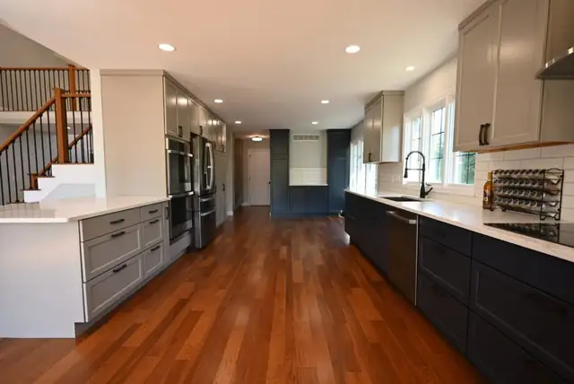 Open-concept kitchen with island, hardwood floors and a rebuilt staircase after a whole-home renovation
