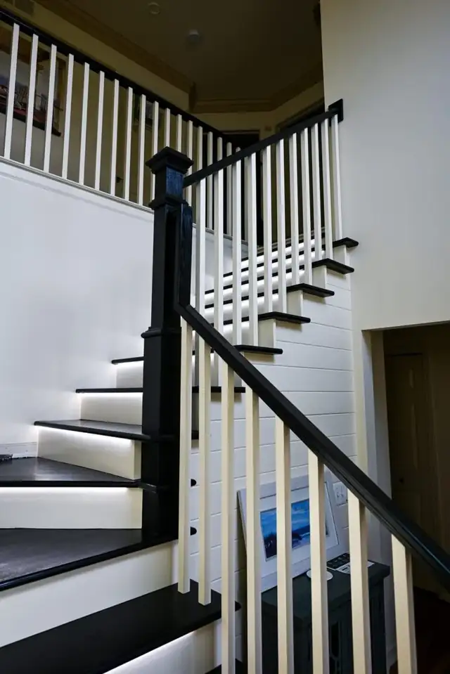 Ypsilanti staircase with a black newel post and handrail, white balusters and a shiplap wall
